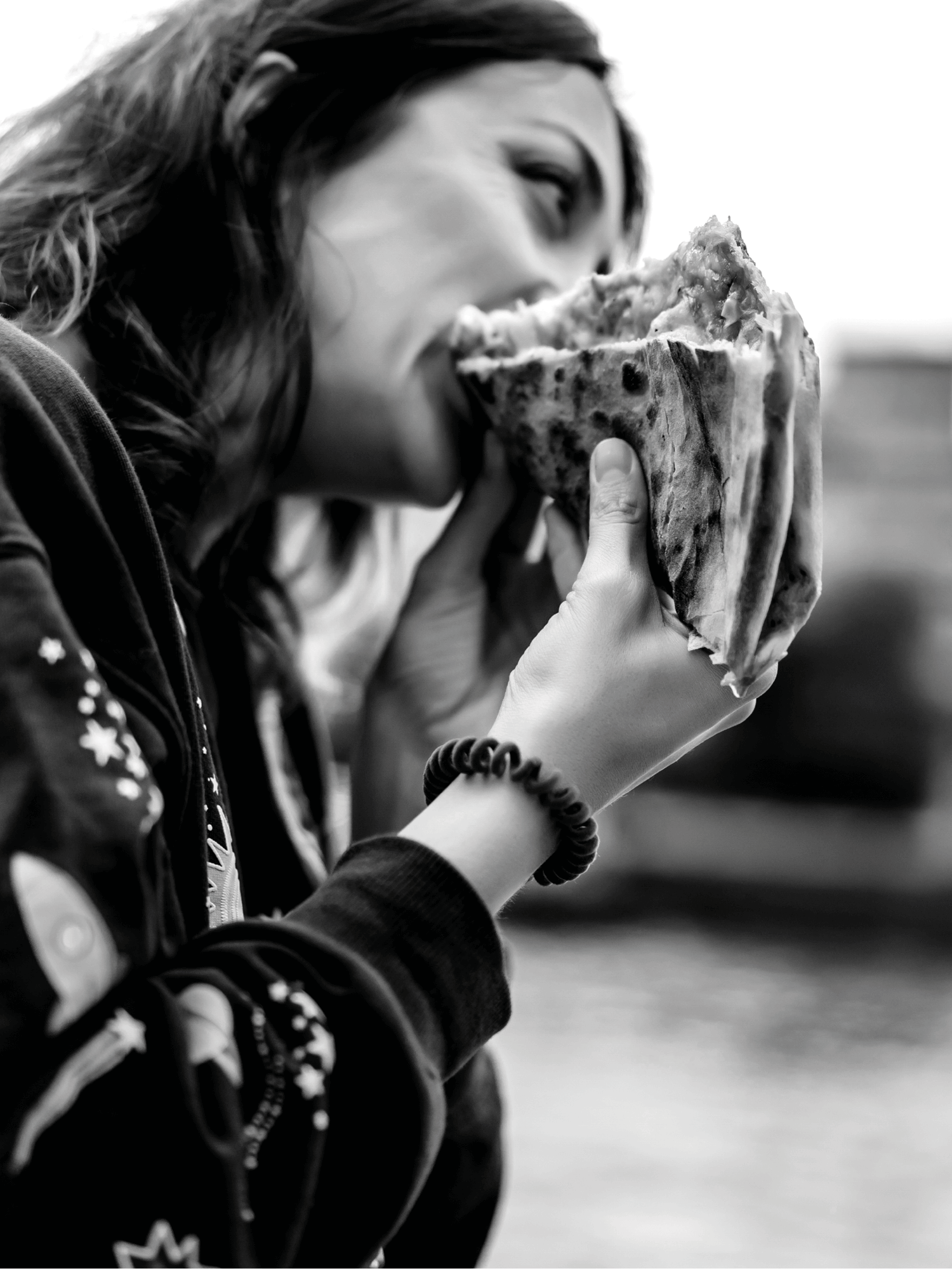 Person beißt in ein großes Sandwich